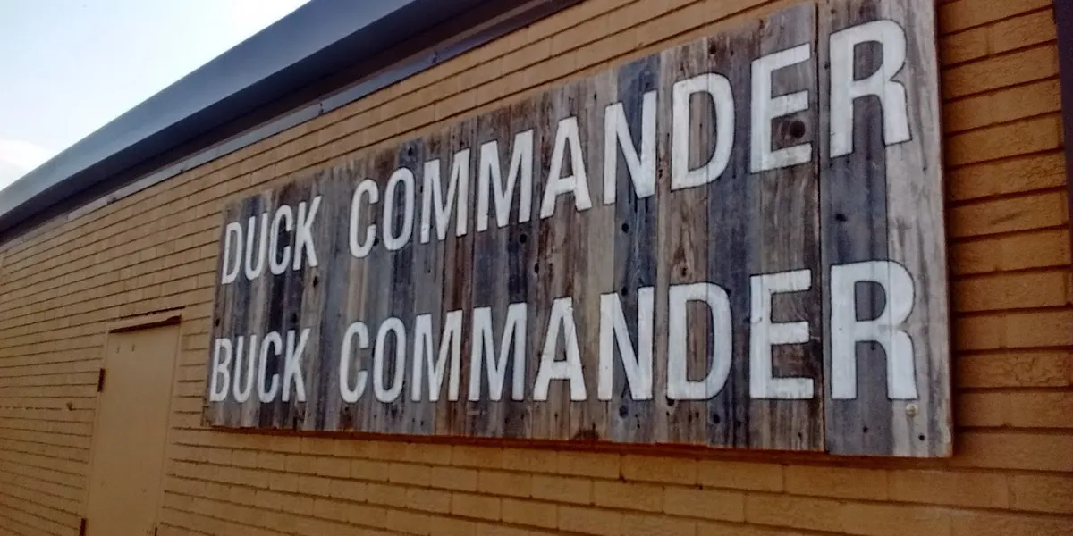 Rustic storefront of Duck Commander with hunting-themed decor, merchandise displays, and TV show memorabilia in a casual...