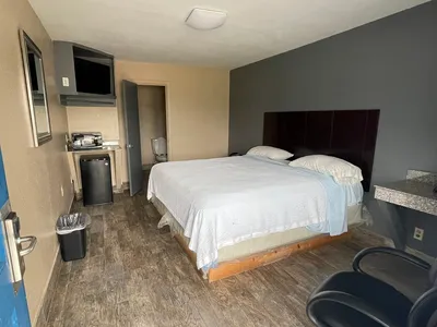 Exterior view of Economy Inn Monroe showing recently renovated motel rooms with window-service reception and parking...