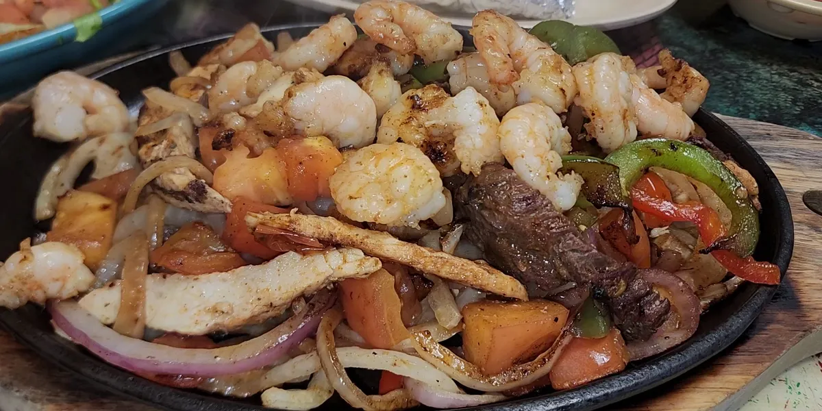 Cozy Mexican restaurant with outdoor seating area, bustling with regular patrons enjoying signature nachos and steak dishes.