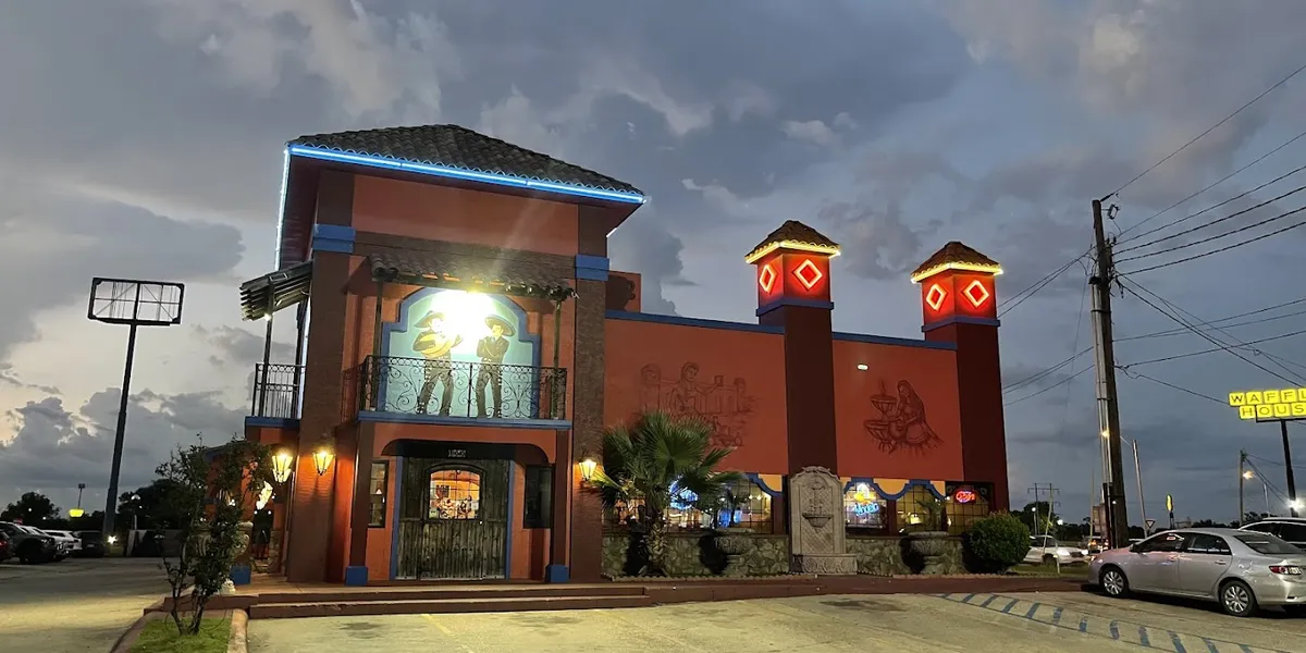 Spacious Mexican restaurant with indoor and outdoor seating areas, colorful decor, and tables set for both intimate...