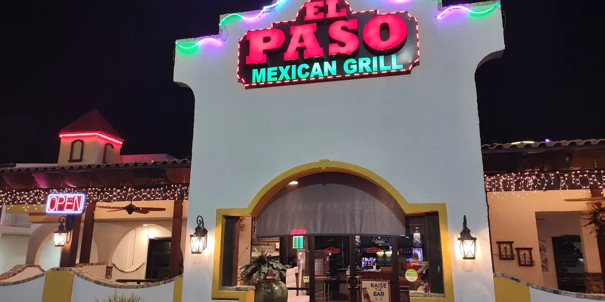 Bright Mexican restaurant with outdoor seating area, serving colorful plates of fajitas and enchiladas alongside chips...