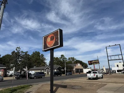 Cozy bakery counter displaying oversized cookies and specialty brownies with outdoor seating area and coffee service station.
