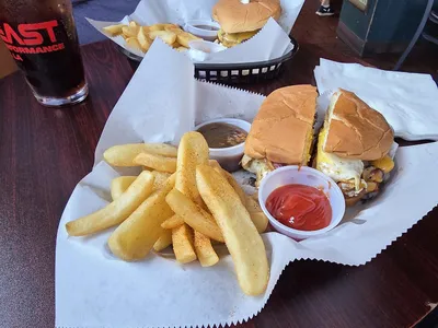 Cozy Irish pub interior with wooden furnishings, live music stage, and bar area where regulars enjoy Guinness and...