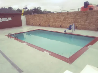 Modern hotel exterior with ample parking, featuring standard Marriott-branded signage in a quiet commercial area of West...