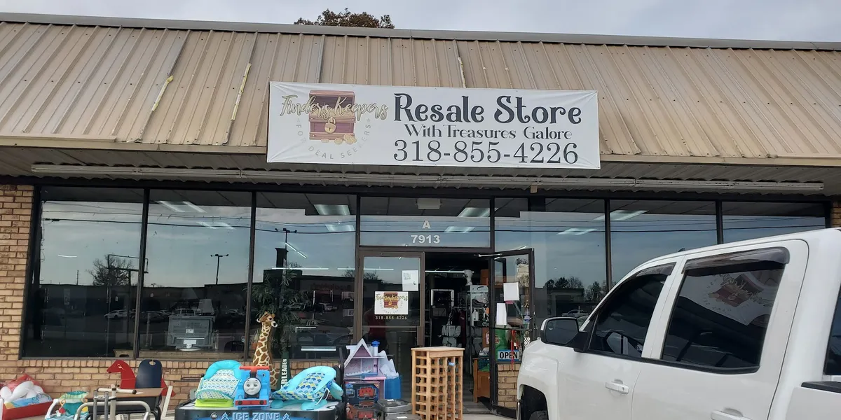 Neatly organized consignment store with rows of furniture, headboards, and display cases of name-brand shoes in a bright,...