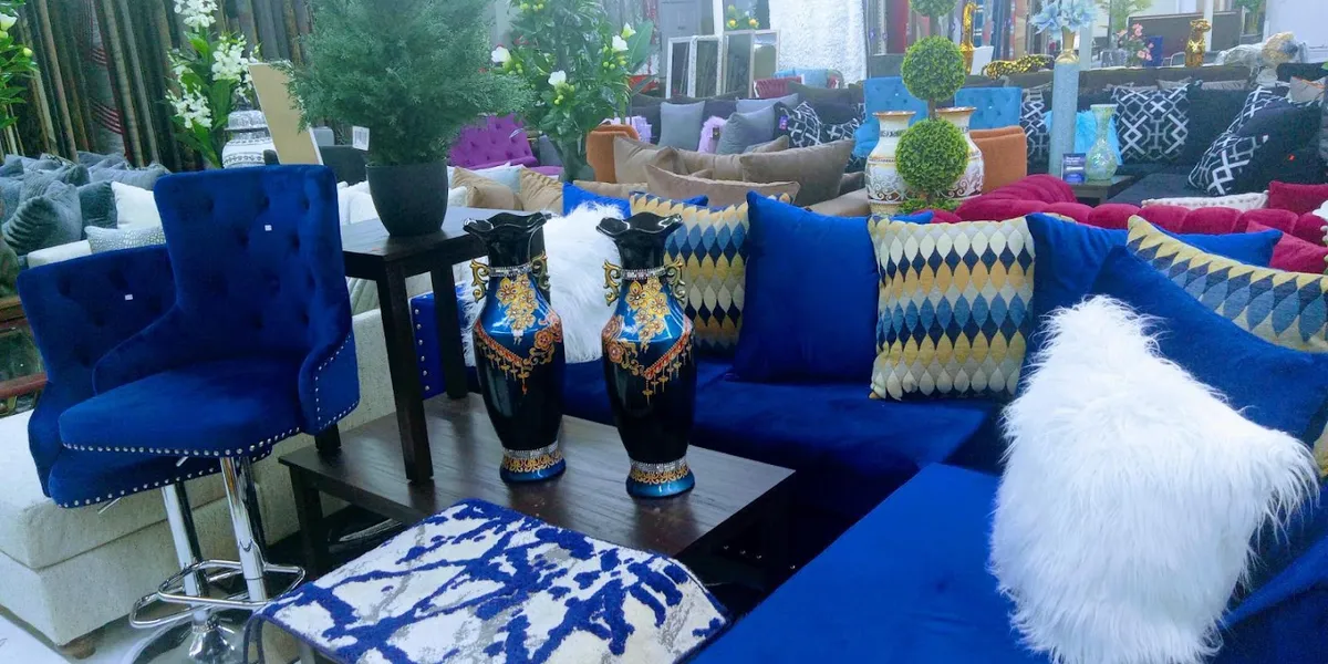 Fully-stocked furniture showroom with ceiling-high inventory of dining tables and beds arranged throughout the spacious...