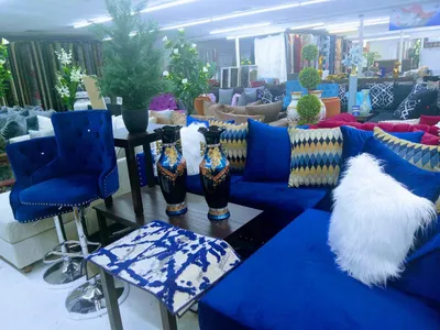 Fully-stocked furniture showroom with ceiling-high inventory of dining tables and beds arranged throughout the spacious...