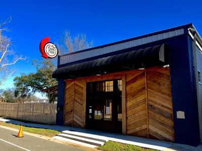 Craft brewery with pizza bar featuring indoor seating and enclosed backyard patio with heaters, brewing equipment visible...