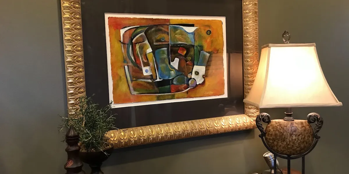 Bright art gallery space displaying Frank Kelley Jr's detailed paintings with multiple works-in-progress visible in the...