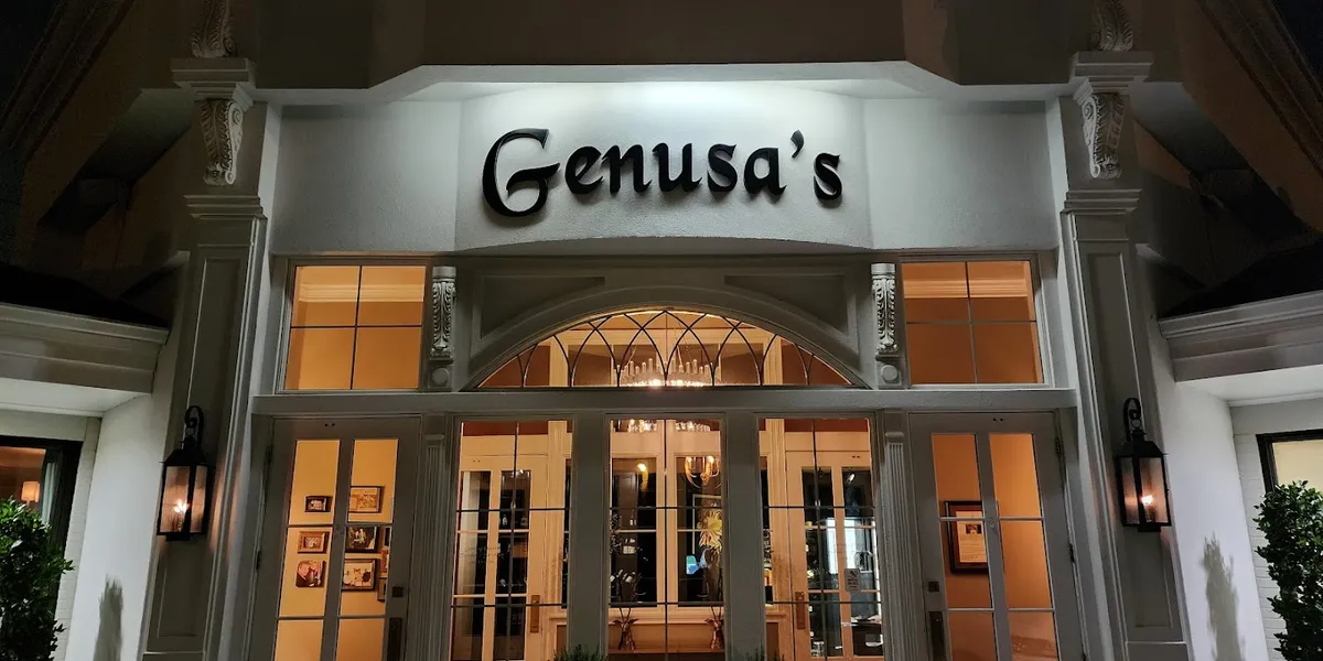 Elegant Italian dining room with dim lighting, white tablecloths, and intimate seating at Genusa's Restaurant on Park...