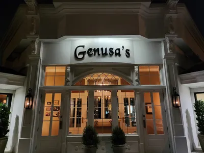 Elegant Italian dining room with dim lighting, white tablecloths, and intimate seating at Genusa's Restaurant on Park...