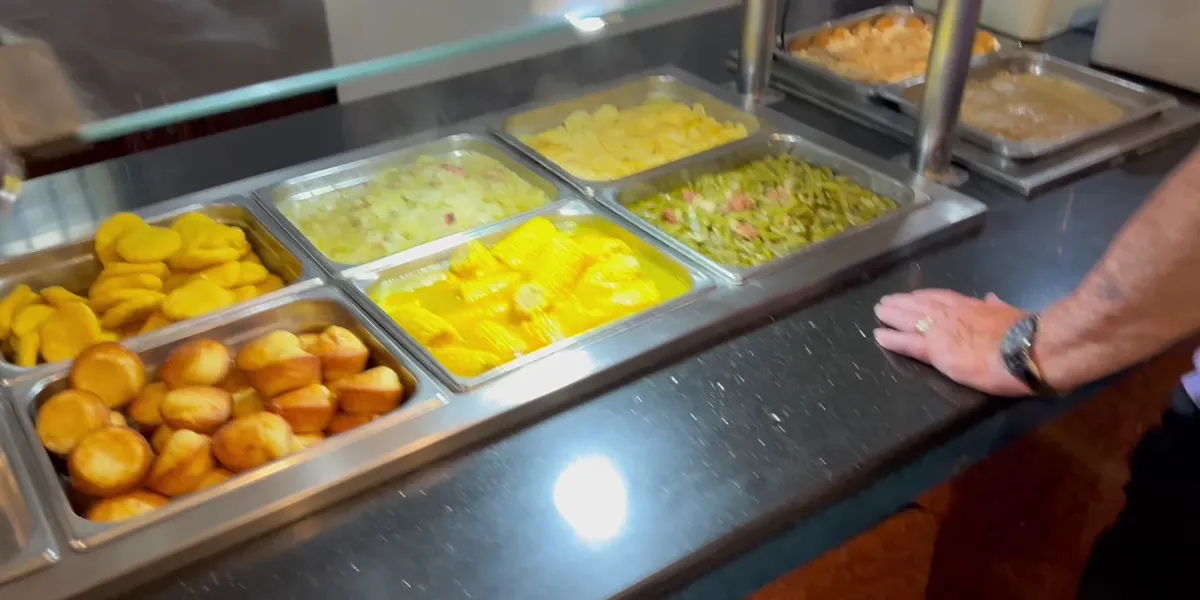 Busy Southern buffet restaurant with multiple steam tables of home-style dishes, crowded dining area, and friendly staff...