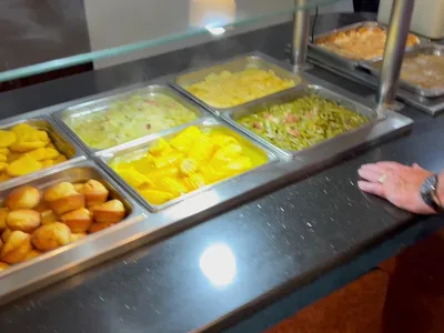 Busy Southern buffet restaurant with multiple steam tables of home-style dishes, crowded dining area, and friendly staff...