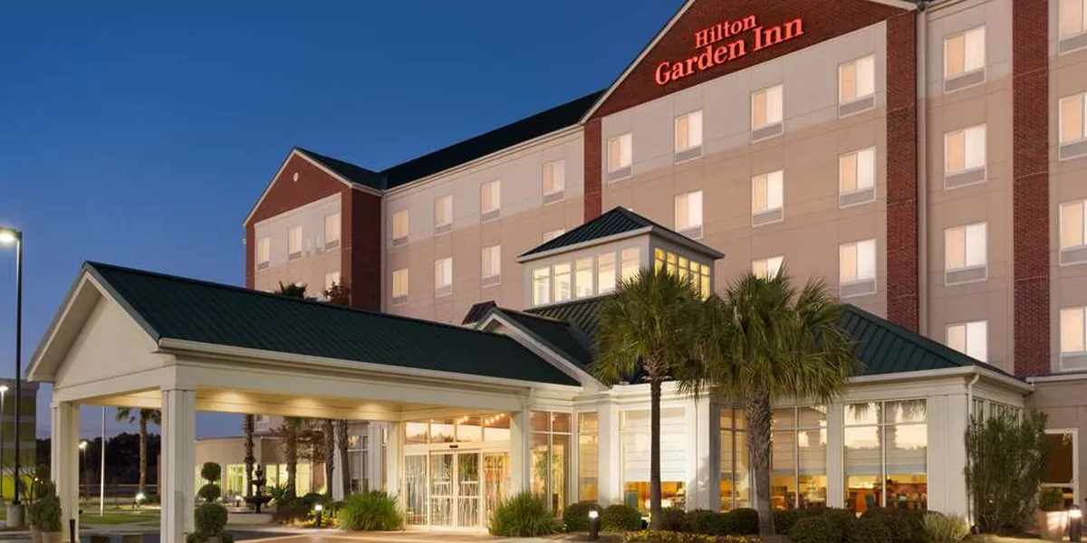 Exterior view of Hilton Garden Inn West Monroe featuring the hotel entrance, surrounded by parking area in a quiet...