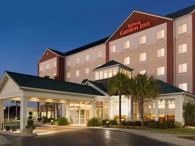 Exterior view of Hilton Garden Inn West Monroe featuring the hotel entrance, surrounded by parking area in a quiet...