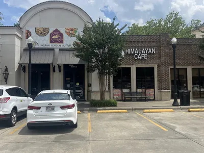 Spacious Himalayan Cafe interior with buffet station, ample seating, and Nepali-inspired decor where travelers and locals...