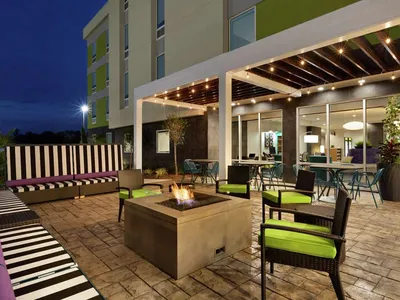 Modern extended-stay hotel featuring spacious suites with kitchenettes, outdoor pool area, and bright lobby with...