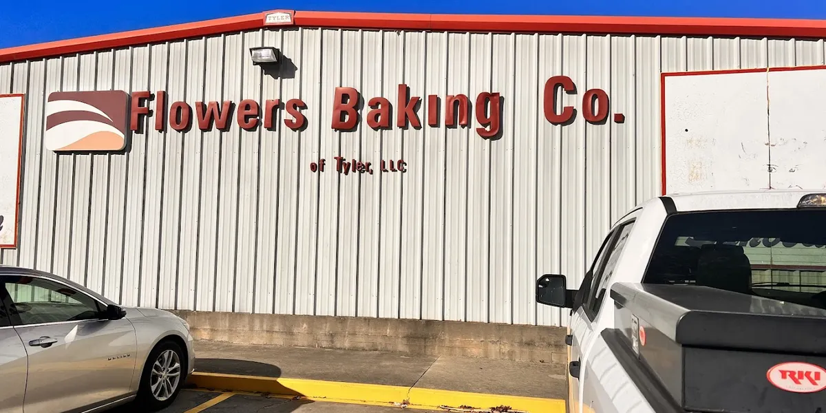 Neatly arranged shelves of discounted bread and snack cakes in a clean, no-frills outlet store with budget-friendly...