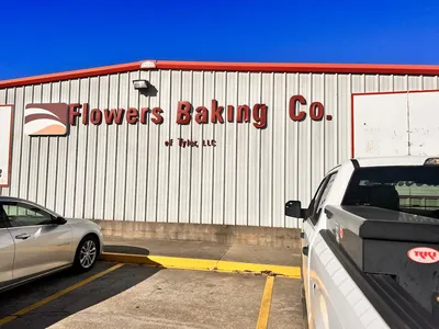Neatly arranged shelves of discounted bread and snack cakes in a clean, no-frills outlet store with budget-friendly...