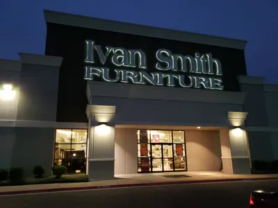 Spacious furniture showroom with casual browsing atmosphere and extensive inventory displays arranged in lifestyle sections.