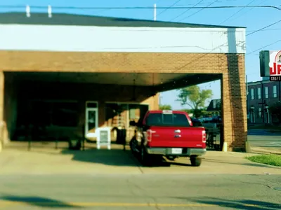 Clean barbecue restaurant with indoor and outdoor seating areas, featuring wood accents and a relaxed atmosphere on...