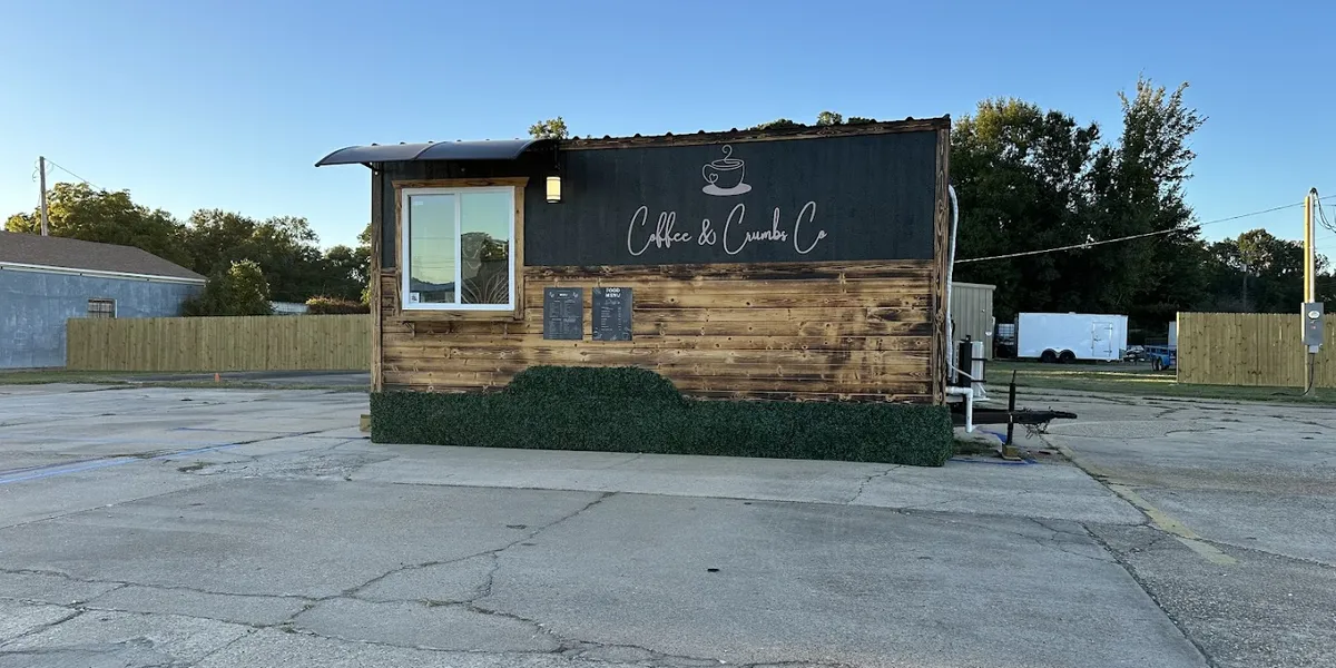 Cozy coffee shop with outdoor seating where a woman owner serves specialty drinks and pastries in a bright, welcoming space.