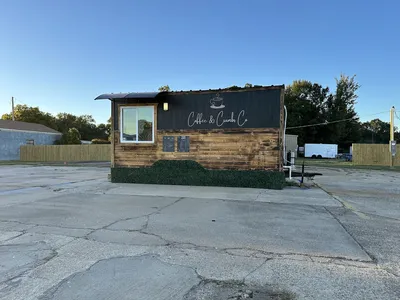 Cozy coffee shop with outdoor seating where a woman owner serves specialty drinks and pastries in a bright, welcoming space.