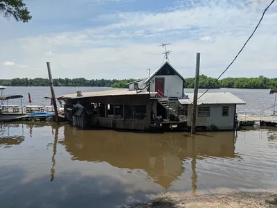 Waterfront RV park with marina docks, wood-fire grill restaurant, and swimming area under open skies at Moon Lake.