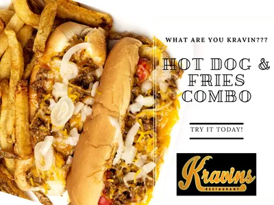 Black and earth-toned restaurant interior with wooden bench seating and a distinctive black barn door separating dining...