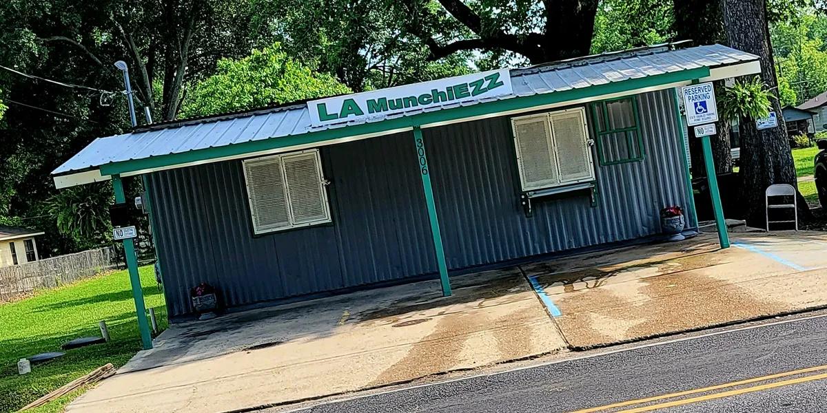 Small takeout restaurant with outdoor seating area, featuring a friendly service window where customers pick up freshly...