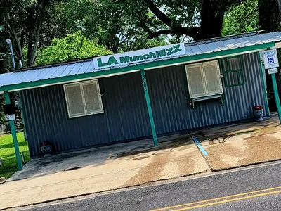 Small takeout restaurant with outdoor seating area, featuring a friendly service window where customers pick up freshly...