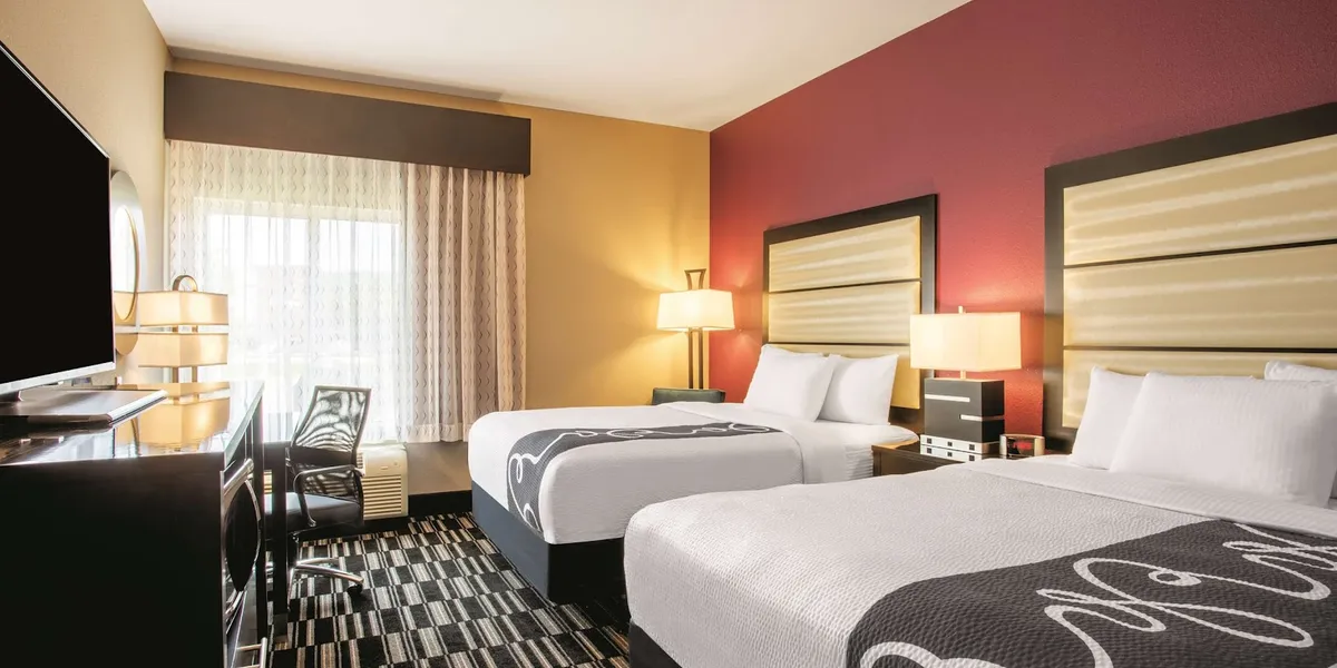 Well-lit La Quinta hotel exterior with convenient parking, featuring spacious rooms and breakfast area, adjacent to...