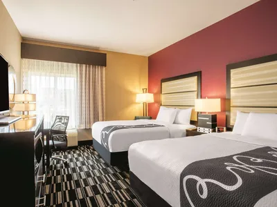 Well-lit La Quinta hotel exterior with convenient parking, featuring spacious rooms and breakfast area, adjacent to...