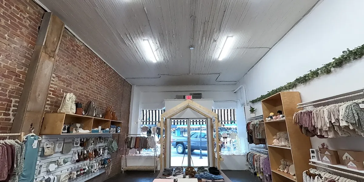 Bright children's boutique displaying neatly arranged high-quality clothing with specialty sections for toddler boys and...