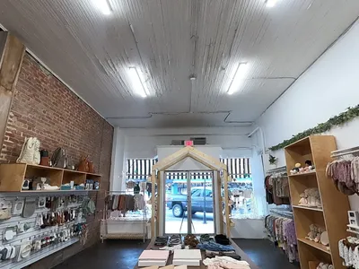 Bright children's boutique displaying neatly arranged high-quality clothing with specialty sections for toddler boys and...