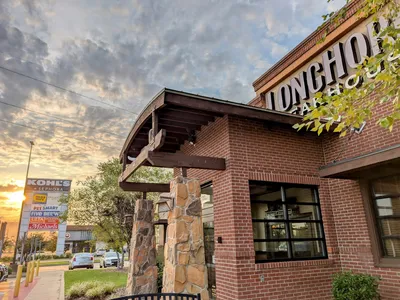 Rustic steakhouse interior with wooden accents and warm lighting, featuring comfortable booth seating and a casual dining...