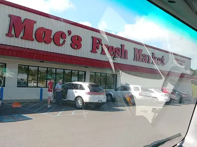 Neighborhood grocery store with well-stocked meat counter, wide aisles, and shopping carts lined up at checkout with 10%...
