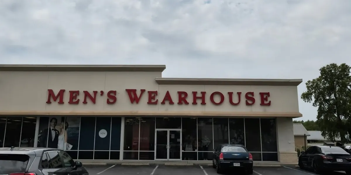 Organized formal menswear displays with suits, dress shirts and accessories in a well-lit retail environment at Pecanland...