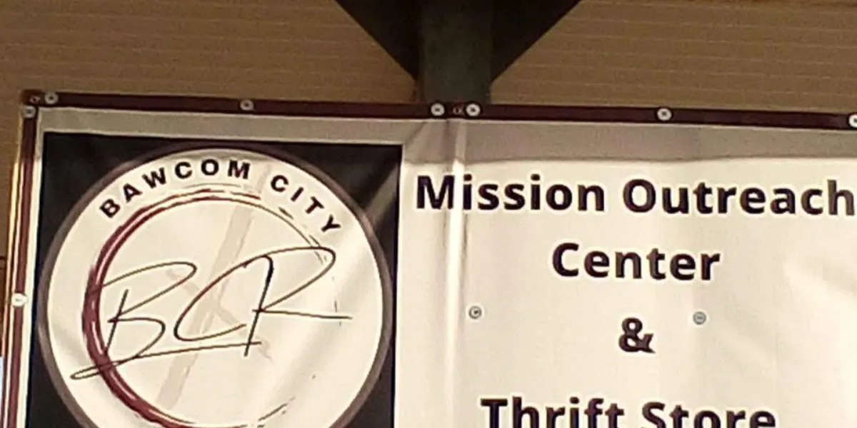 Spacious thrift store with well-organized racks of clothing, furniture displays, and household items in a bright,...