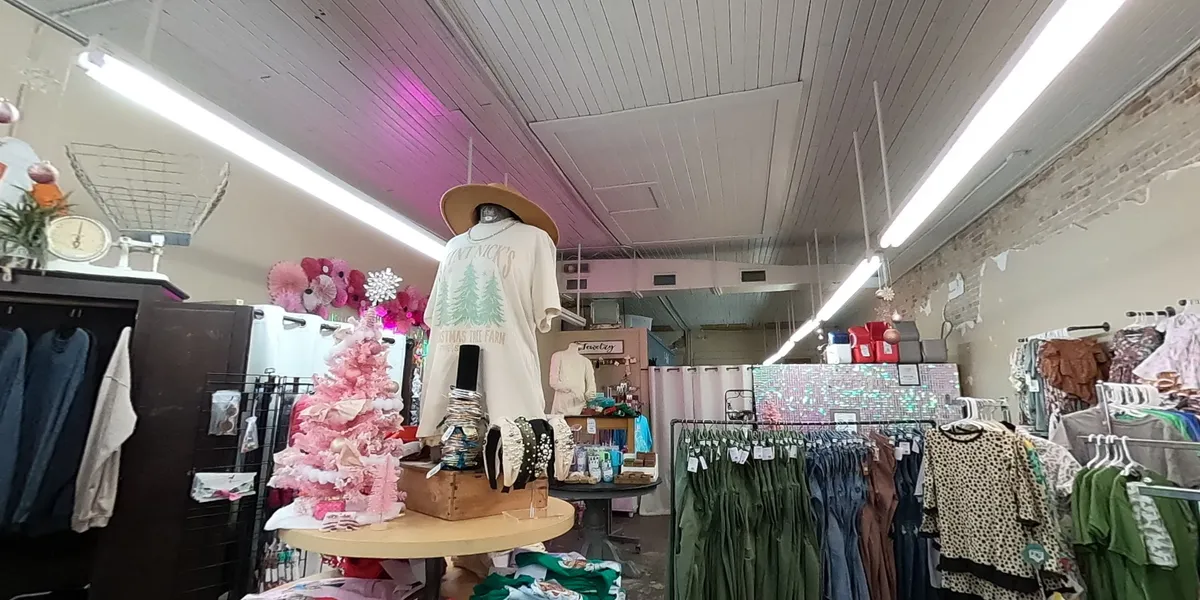 Bright, homey boutique with neatly arranged clothing displays and monogramming samples, creating a warm atmosphere for...