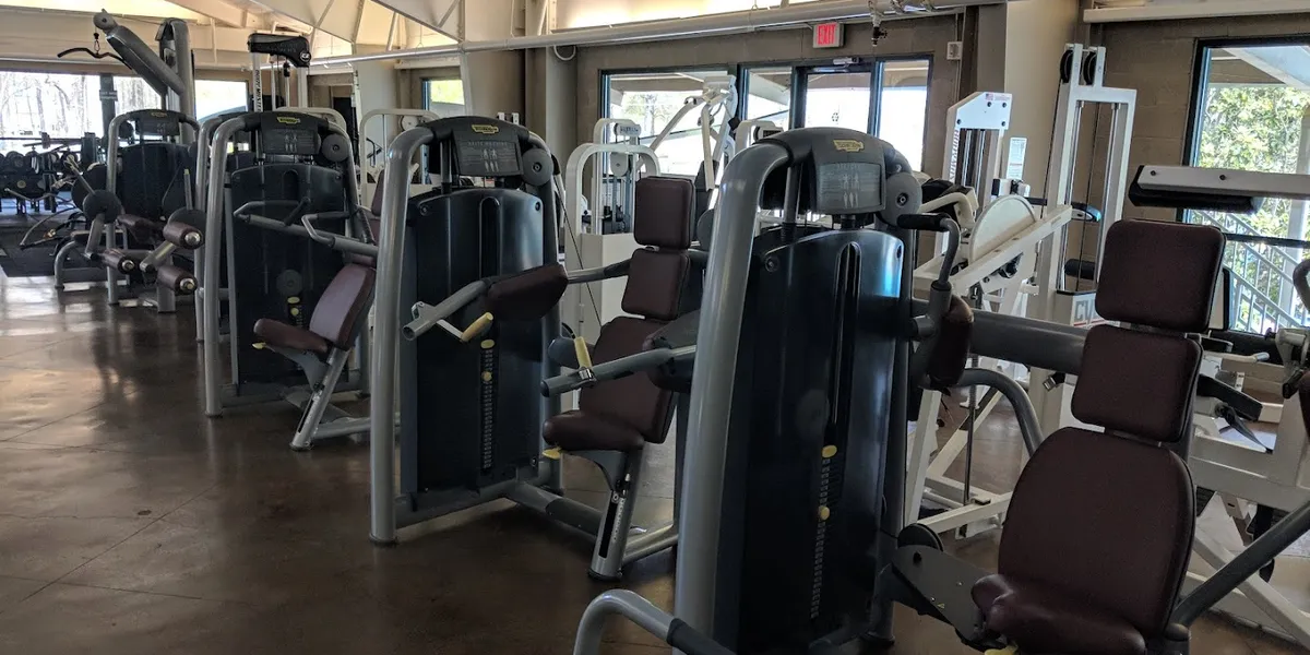 Spacious fitness center with renovated clay tennis courts, workout equipment area, and 25-meter swimming pool under...