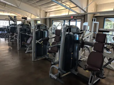 Spacious fitness center with renovated clay tennis courts, workout equipment area, and 25-meter swimming pool under...