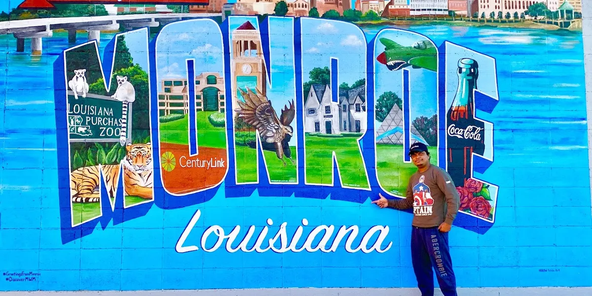 Colorful mural painted on the side of a building in downtown Monroe, situated near the river with pedestrians viewing the...