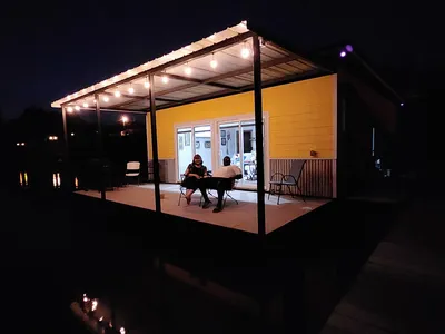 Serene waterfront view of Moon Lake showing floating cabins with fishing decks, kayaks at the shoreline, and tree-lined...