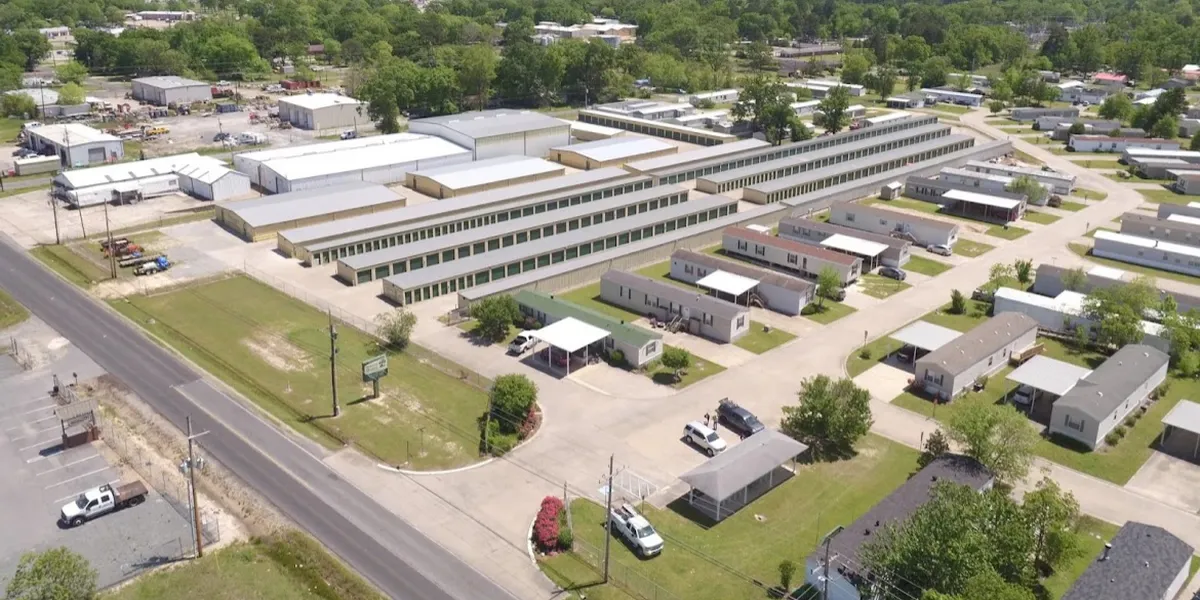 Neat rows of manufactured homes with clean grounds and separate storage facilities, showcasing controlled entry points...