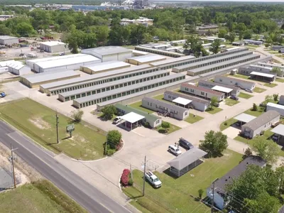Neat rows of manufactured homes with clean grounds and separate storage facilities, showcasing controlled entry points...