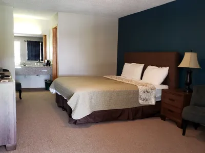 Modest roadside motel with clean, simple rooms featuring comfortable beds, basic furnishings, and ample parking for road...