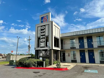 Exterior view of Motel 6 West Monroe showing accessible parking area, room entrances, and Constitution Drive location.