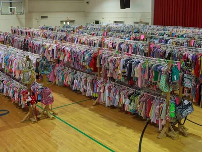 Organized displays of gently-used baby items and toys at Munchkin Market consignment shop with bright lighting and...