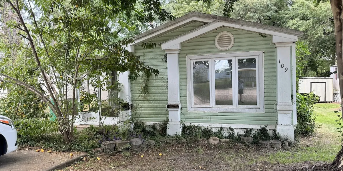 Tree-lined mobile home community with well-spaced units creating a village-like atmosphere, featuring both newer and...